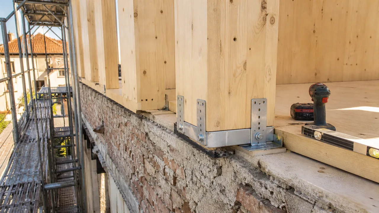 Dettaglio costruttivo di una sopraelevazione in legno su un edificio esistente in muratura a Brescia