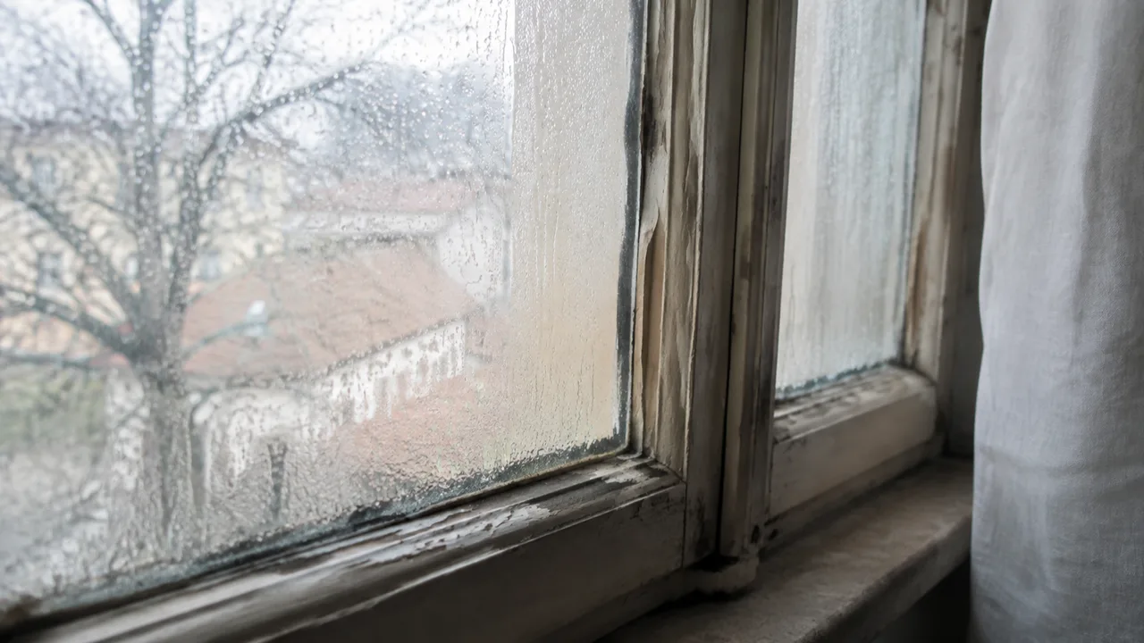 Vecchio infisso con condensa sul vetro in una casa a Brescia prima della sostituzione